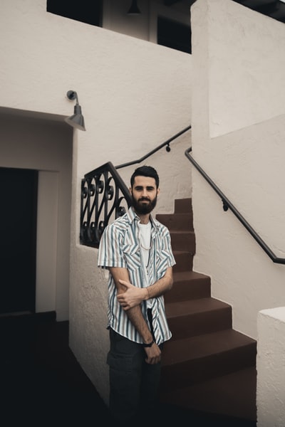 Dressed in blue and white striped polo shirt boy stood on the stairs
